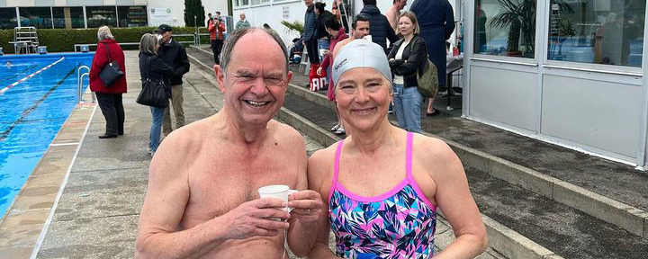 Zwei ältere Schwimmer in Badebekleidung am Beckenrand beim Anschwimmen