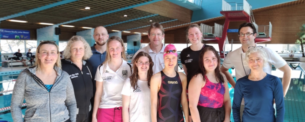 Gruppenbild der Masters-Schwimmerinnen und Betreuer am Hallenbadbecken