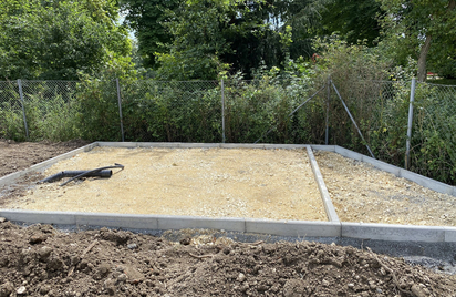 Ausgeebneter Schotterunterbau mit Betonrand und flexiblen Drainagerohren