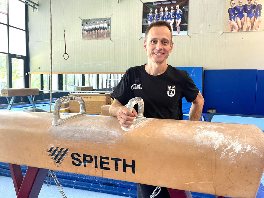 Mann in SSV 1846-Shirt neben Sprungpferd mit SPIETH-Logo