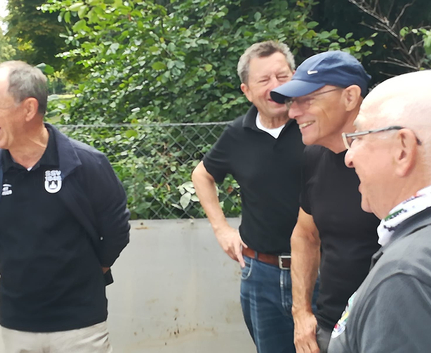 Four older men laughing together outdoors