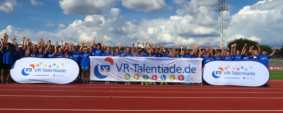 Kinder in blauen Trikots hinter Banner mit Aufschrift VR-Talentiade
