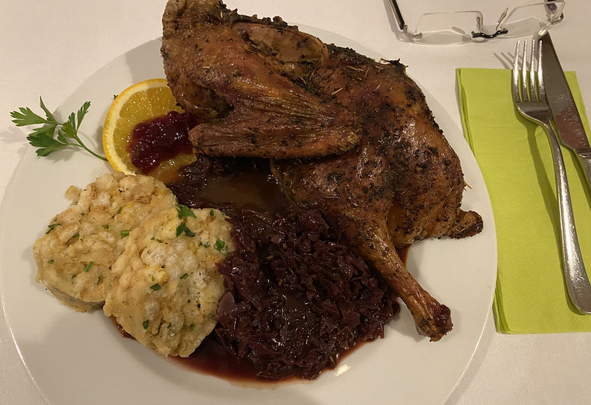 Geröstetes Geflügel mit Knödeln Rotkohl und Orangenscheibe