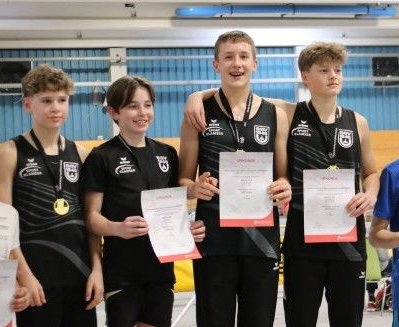 vier jugendliche Leichtathleten in schwarzen Trikots mit Urkunden