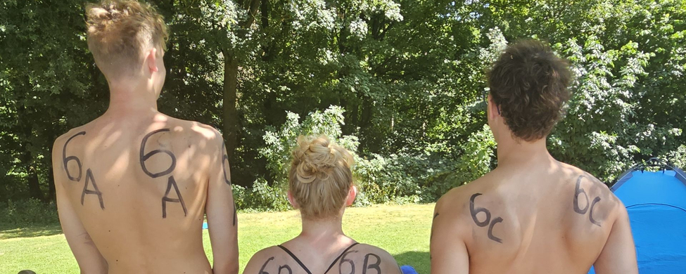 Drei Personen in Badebekleidung stehen mit 6A 6B 6C auf Rücken