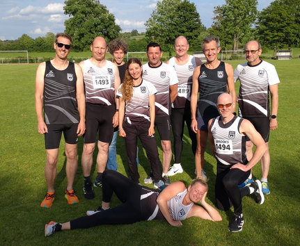 Leichtathletik-Masters-Team auf Rasen mit Brooks 1494 Startnummer