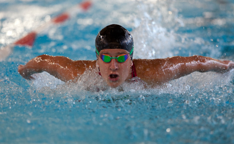 Schwimmer mit Schwimmkappe und Schwimmbrille beim Schmetterlingsschwimmen im Wettkampf