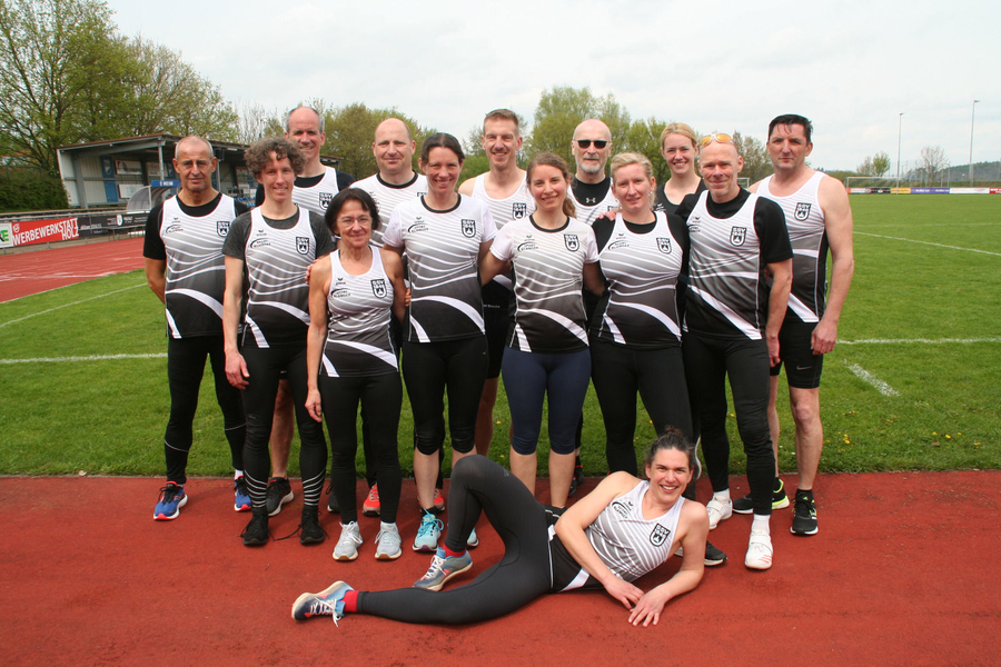 W30- und M50-Teams posieren auf Laufbahn