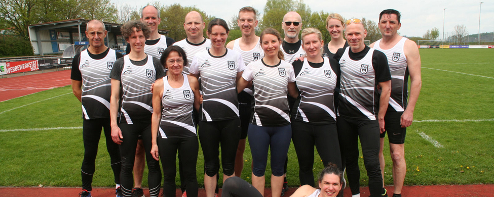 W30- und M50-Teams posieren auf Laufbahn