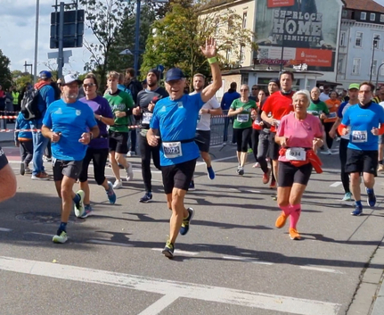 Mehrere Läufer beim 10 km Stadtlauf vorderer Läufer winkt