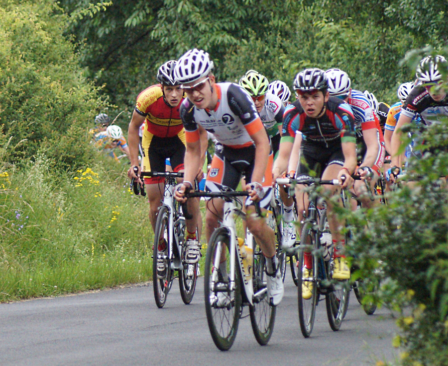 Radrennfahrer in engem Feld auf Landstraße