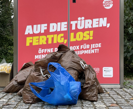 Müllsäcke gestapelt vor roter Box mit Text Auf die Türen, fertig, los