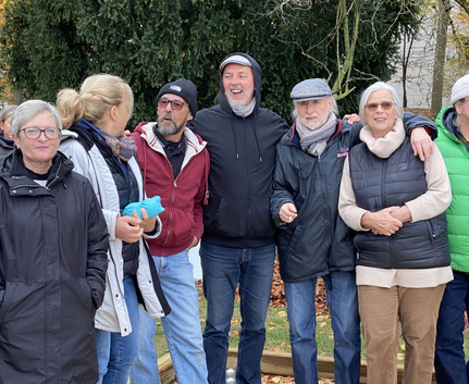 Gruppe erwachsener Menschen umarmt sich draußen im Herbst
