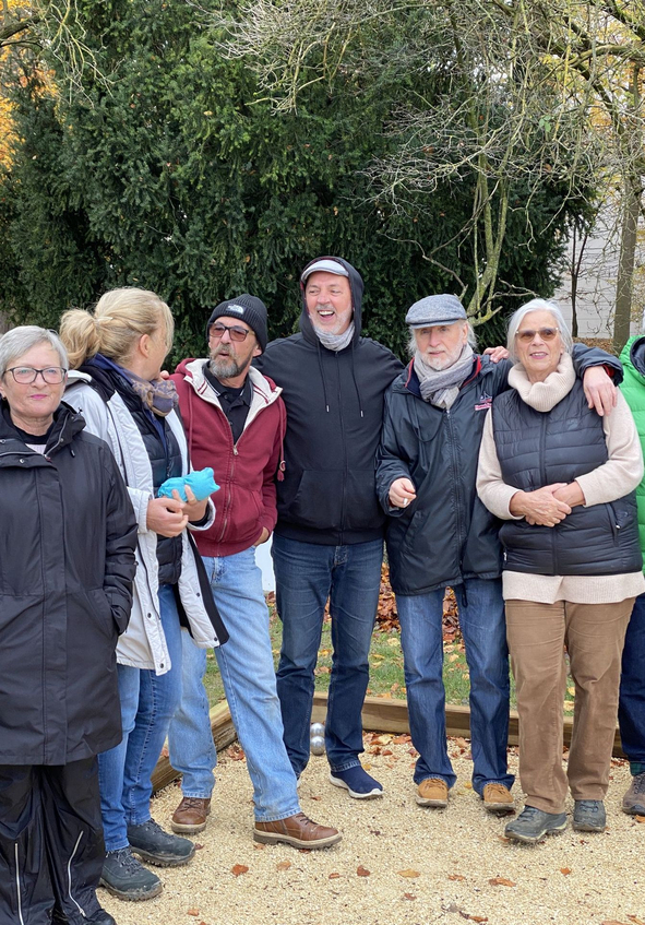 Gruppe erwachsener Menschen umarmt sich draußen im Herbst