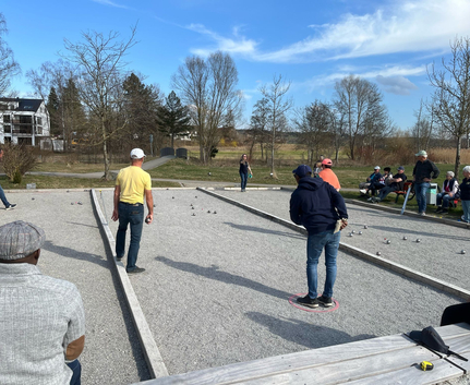 Spieler beim Boule Freundschaftsturnier auf mehreren Spielbahnen