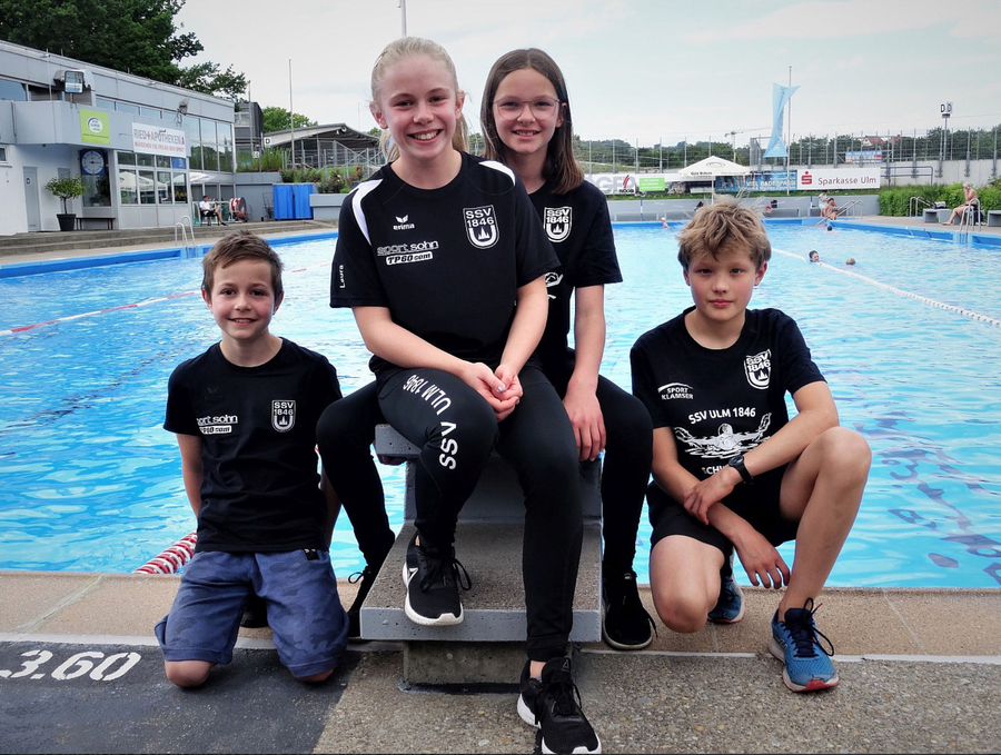 Vier junge Schwimmer in SSV Ulm 1846 Shirts am Freibadrand beim Landesvielseitigkeitstest