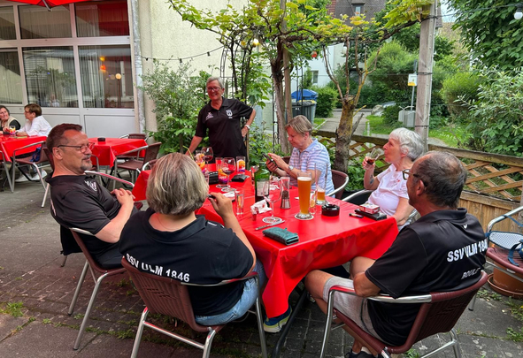 Sechs Personen an rotem Terrassentisch mit SSV ULM 1846 auf Shirts