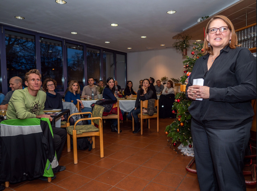 Sprecherin hält Ansprache vor Vereinsmitgliedern neben geschmücktem Weihnachtsbaum