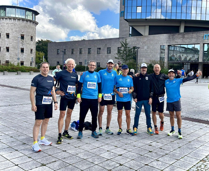 Gruppe von Läufern mit Startnummern vor Gebäude