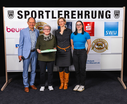Hall of Fame Gewinner Cosma Müller und Julia Gastel sowie Edith Pichler gemeinsam mit Präsident Willy Götz Vier Personen vor SSV Ulm Sportlerehrung Banner, ältere Frau mit Geschenk