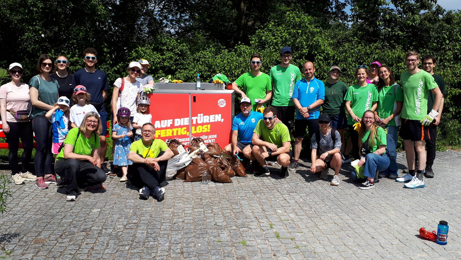 Plogging Aktion - SSV Ulm 1846 e.V. Plogging-Gruppe mit gesammeltem Müll vor Schild AUF DIE TÜREN, FERTIG, LOS