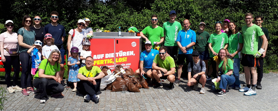 Plogging Aktion - SSV Ulm 1846 e.V. Plogging-Gruppe mit gesammeltem Müll vor Schild AUF DIE TÜREN, FERTIG, LOS
