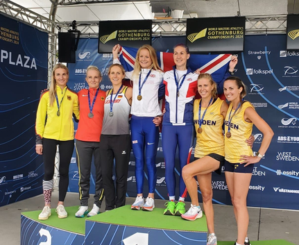 Athletinnen auf Podest mit Medaillen und Flagge
