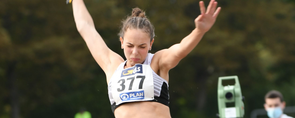 Athletin im Weitsprung mit Startnummer 377 in der Luft