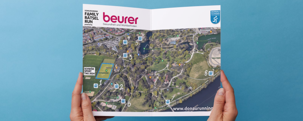 DONAURUNNING Family Rätsel Run powered by Beurer Hände halten Orientierungsplan mit Beurer- und DONAURUNNING-Logo