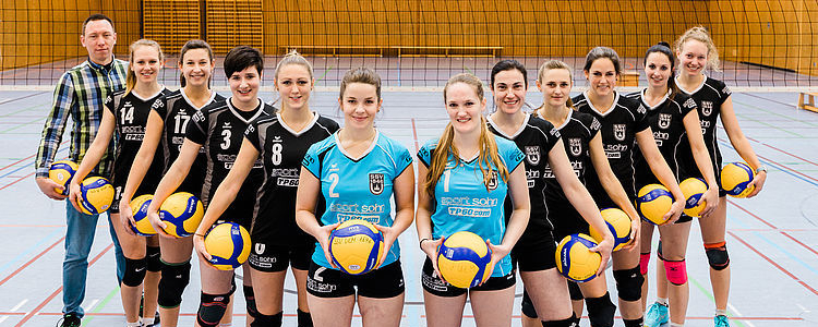Volleyballteam des SSV Ulm in Sporthalle mit Volleyballbällen
