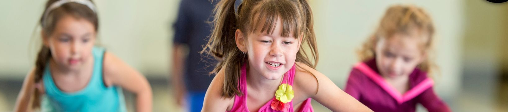 Drei Kinder klettern über Weichbodenmatten beim Kinderturnen