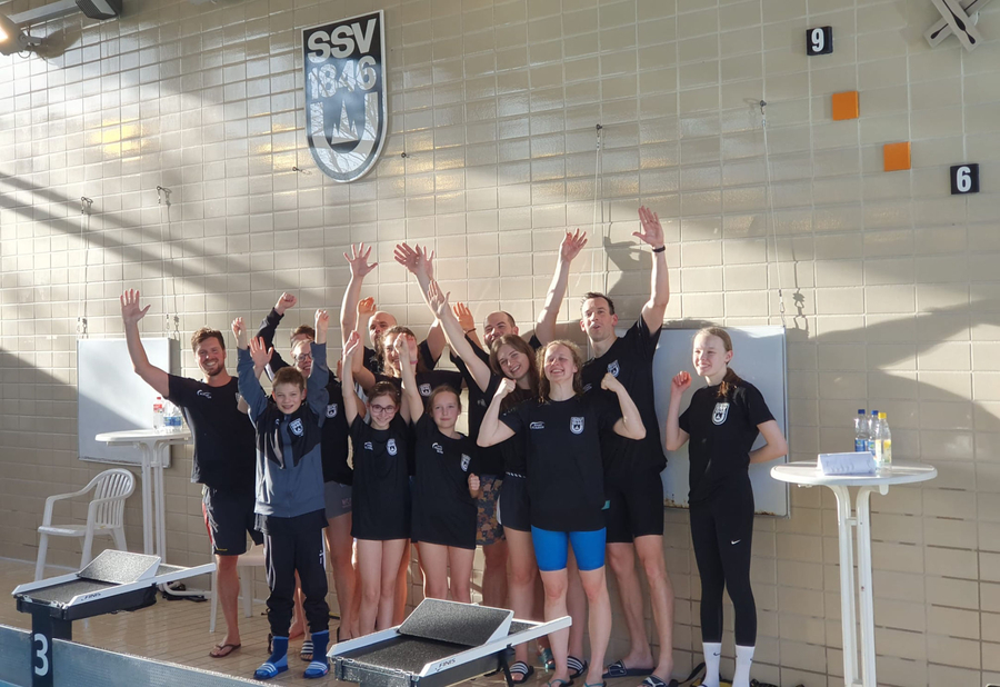SSV 1846 Wappen über jubelnder Schwimmmannschaft am Startblock