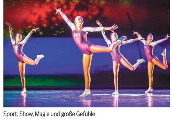 Vier Tänzer in violetten Trikots heben synchron ein Bein auf Bühne