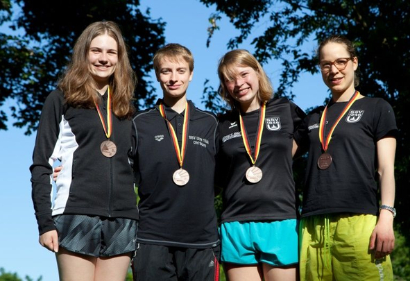 Vier Jugendliche nebeneinander mit Bronzemedaillen