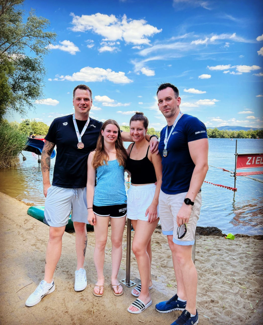 Vier Schwimmer am Seeufer mit Medaillen