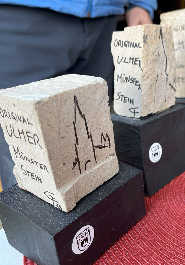 Steinblöcke mit Aufschrift ORIGINAL ULMER MÜNSTER STEIN auf schwarzen Sockeln