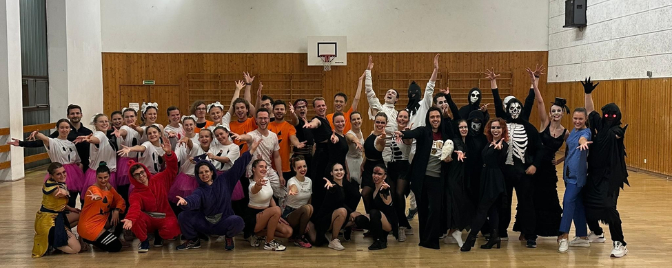 Große Tanzformation in Kostümen posiert in Sporthalle