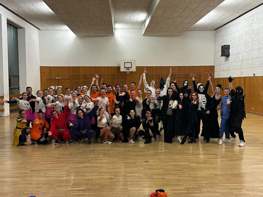Große Tanzformation in Kostümen posiert in Sporthalle