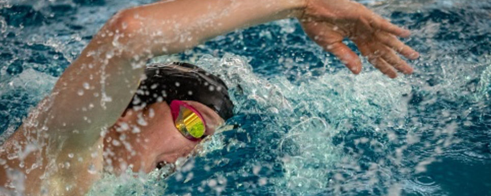 Schwimmer beim Kraulen im Becken mit Spritzwasser
