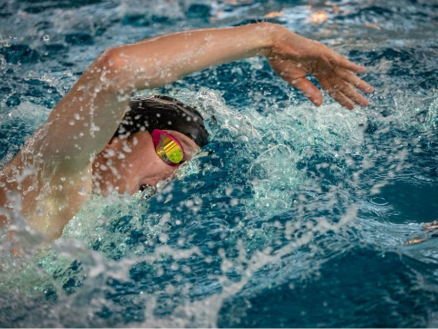 Schwimmer beim Kraulen im Becken mit Spritzwasser
