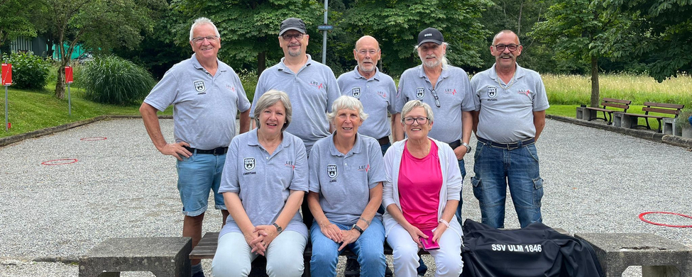 Acht Vereinsmitglieder in grauen Poloshirts auf Boule-Bahn mit Jacke SSV ULM 1846
