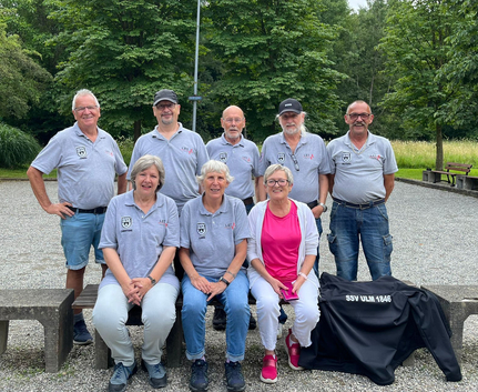 Acht Vereinsmitglieder in grauen Poloshirts auf Boule-Bahn mit Jacke SSV ULM 1846