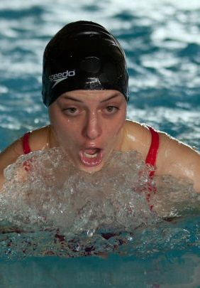 Schwimmende Person mit Badekappe mit Schrift Speedo atmet über Wasser