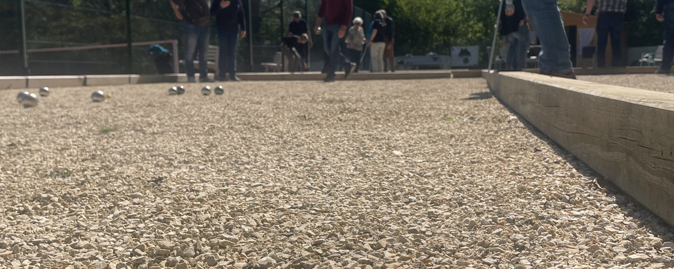 Boule-Kugeln und grüner Zielball auf Schotterplatz