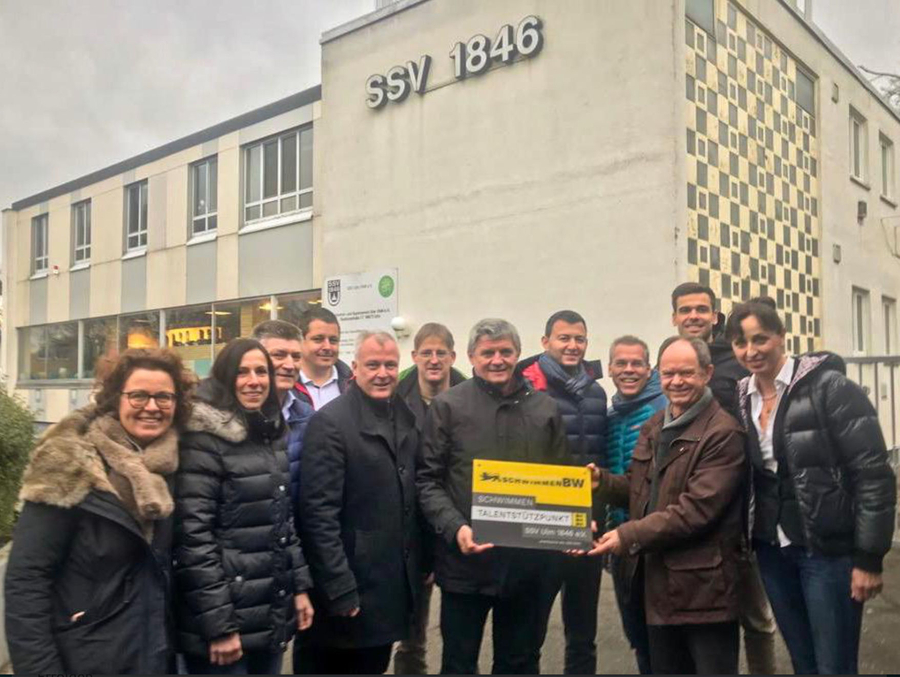 Gruppe hält Schild Talentstützpunkt vor SSV 1846 Gebäude
