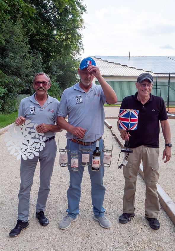 Drei Männer auf Boule-Bahn mit Preisen und Union-Jack-Lampenschirm