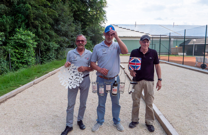 Drei Männer auf Boule-Bahn mit Preisen und Union-Jack-Lampenschirm
