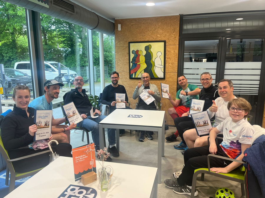 Gruppe von Läuferinnen und Läufern mit Ready for 10 Programmheften