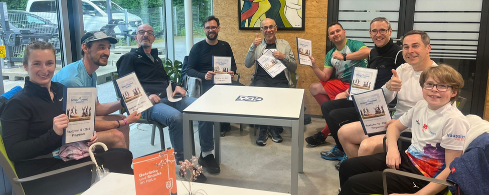 Gruppe von Läuferinnen und Läufern mit Ready for 10 Programmheften
