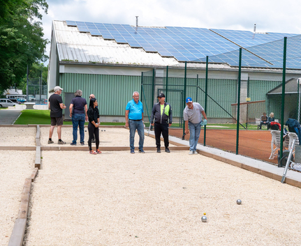 Gruppe von Spielerinnen und Spielern beim Bouleturnier auf Kiesbahn